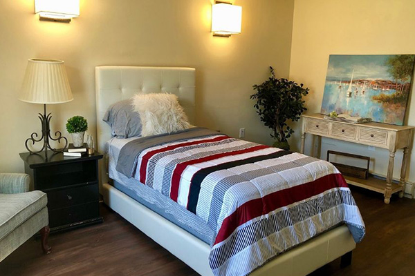 Room at Cambridge Crossing with a single bed, an armchair and plenty of lighting